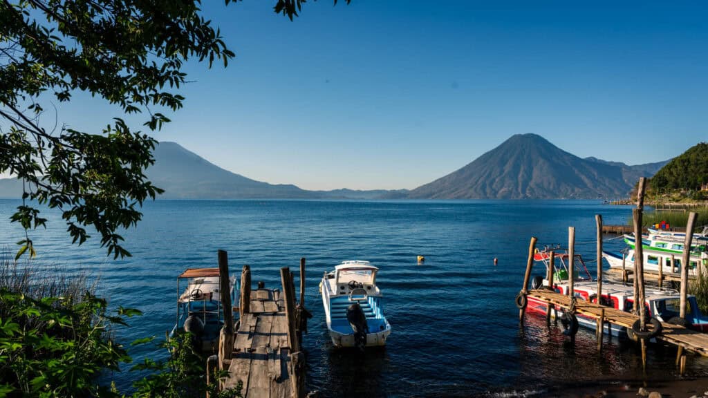 The picture perfect docks of Lake Atitlan, Guatemala with distant volcanoes towering in the background