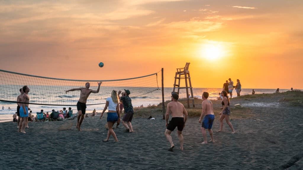 A group of travellers enjoying some beach volleyball in golden hour. Played at Cocori lodge in el paredon Guatemala