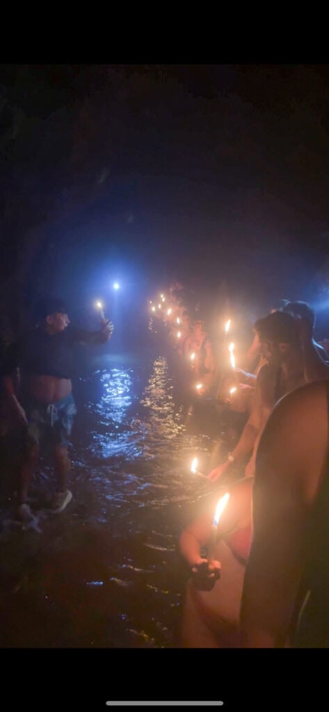A line of tourists being led through the caves of Semuc Chapey with nothing but candles for light