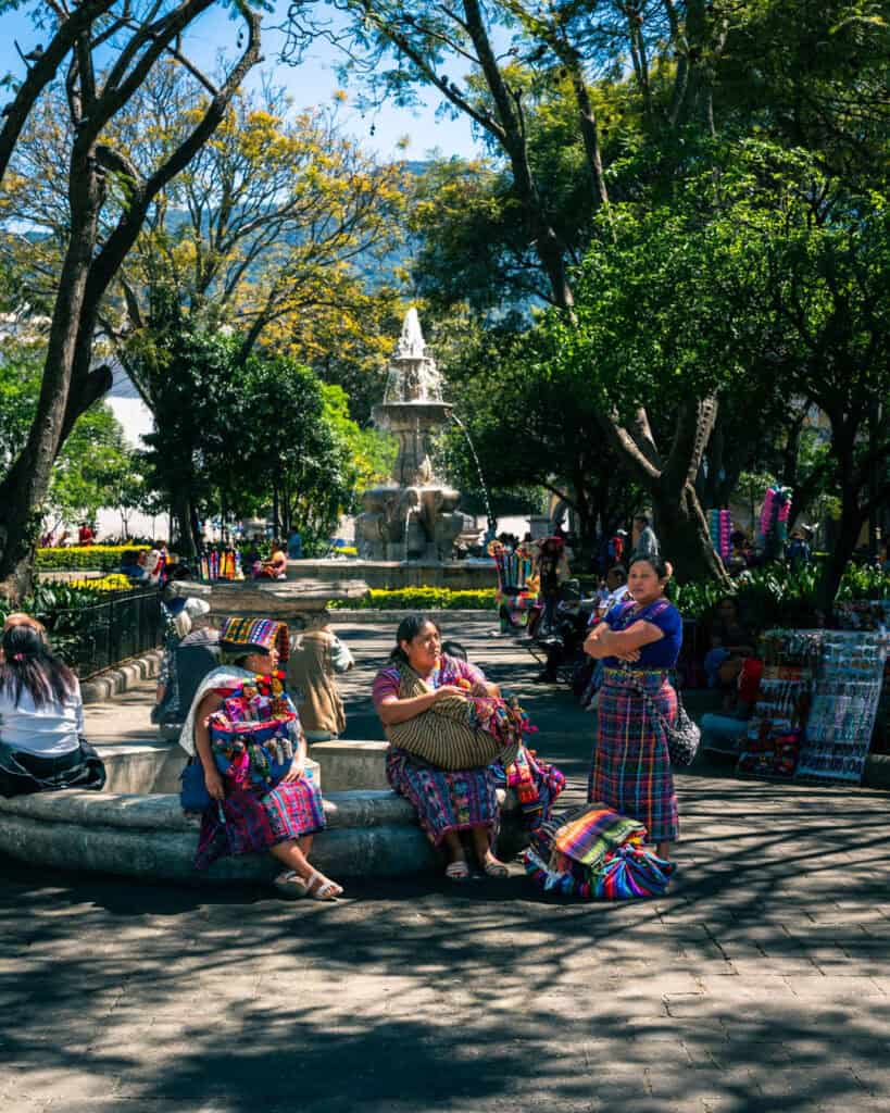 three local women in traditional dress at Parque central in Antigua Guatemala