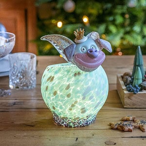 Von innen mit einem LED-Teelicht beleuchtete Glasschale FELIX auf einem weihnachtlich dekoriertem Esstisch, im Hintergrund ein Weihnachtsbaum.