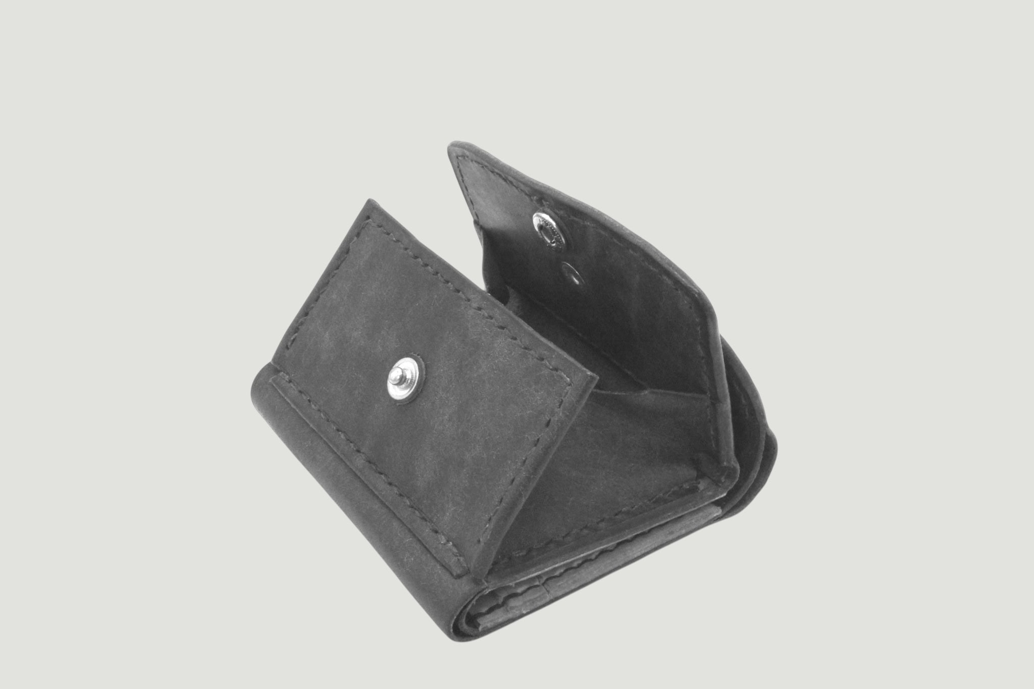 ブラックレザーの財布、折りたたみ式でスナップボタン付きのシンプルなデザイン。.