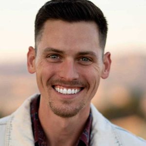 A smiling man outdoors demonstrating mental clarity and focus, illustrating the benefits of brain performance technology for cognitive improvement and peak mental health.