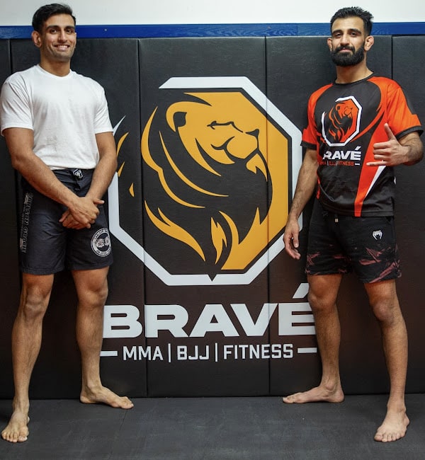 High-level athletes training at Bravé MMA and Fitness gym with logo background.