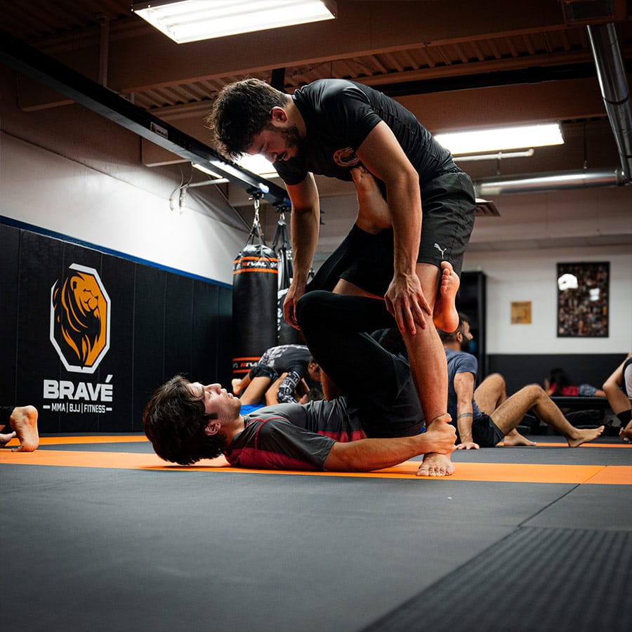 Engaging MMA training session at Bravé MMA and Fitness with fighters practicing ground techniques.