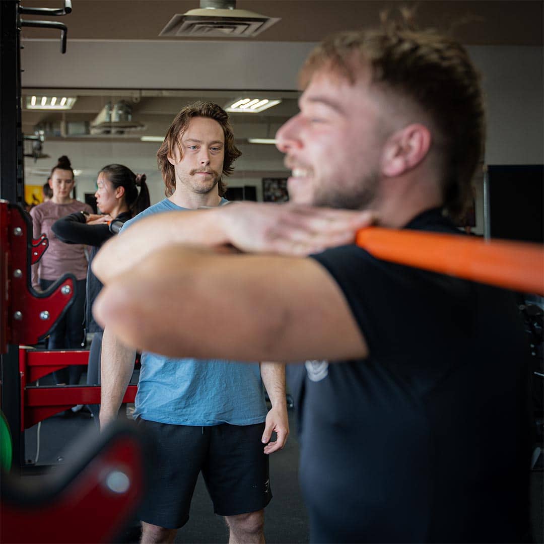 Focused trainer observing client during MMA workout at Bravé MMA and Fitness gym.