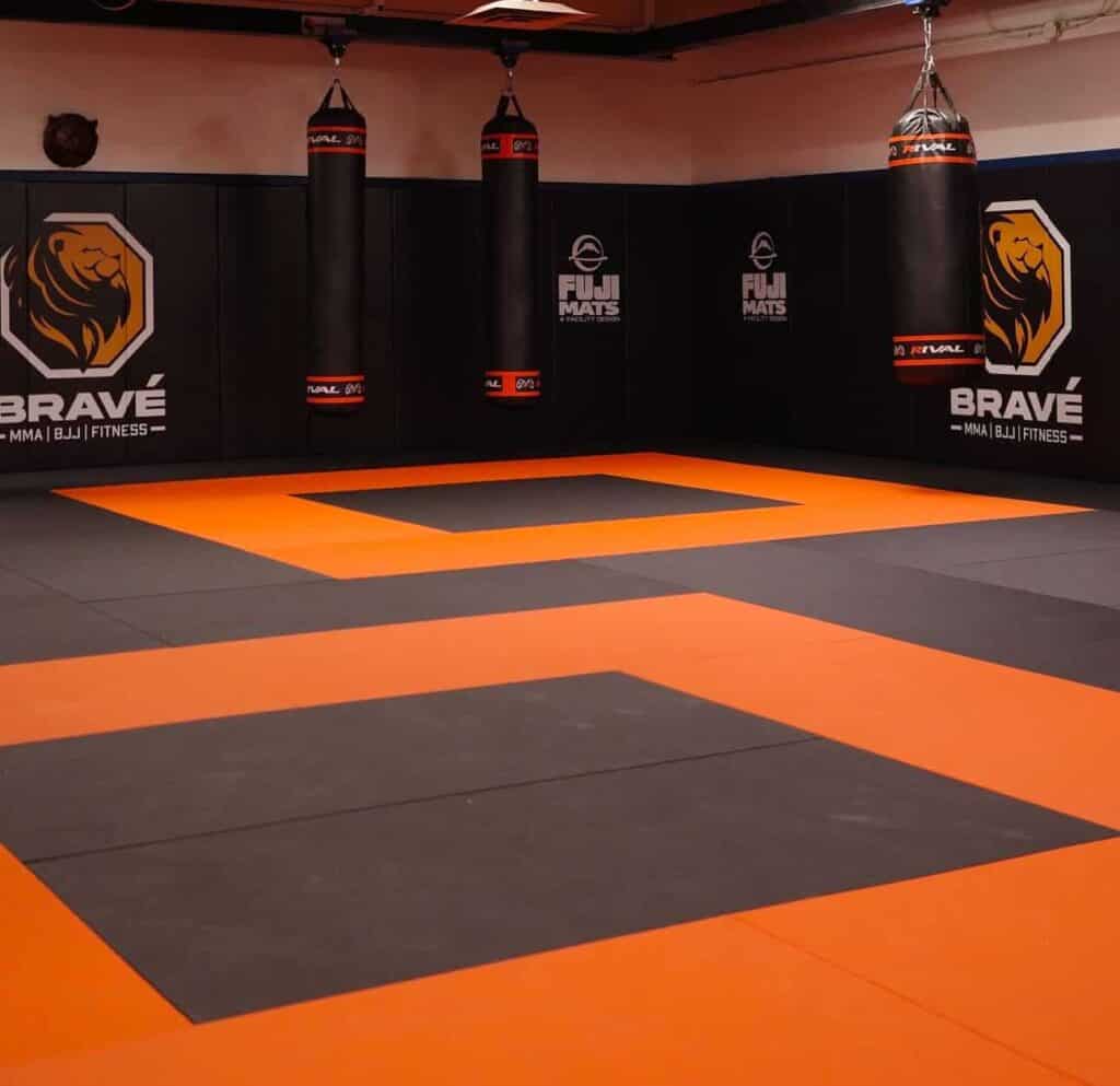 Vibrant martial arts training area with punching bags at Bravé MMA and Fitness facility.
