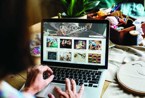 Person browsing DIY crafting website on laptop.