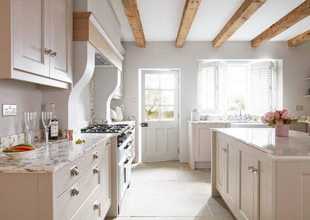 Cream and white classic kitchen with wooden beams, modern cabinetry, and a spacious island, showcasing Broadoak Kitchens Ltd’s expert kitchen design and installation services.