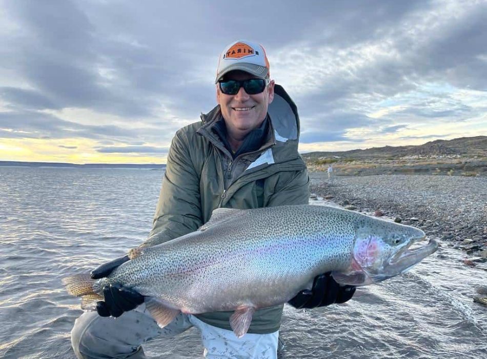 angler holding large rainbow trout caught in jurassic lake