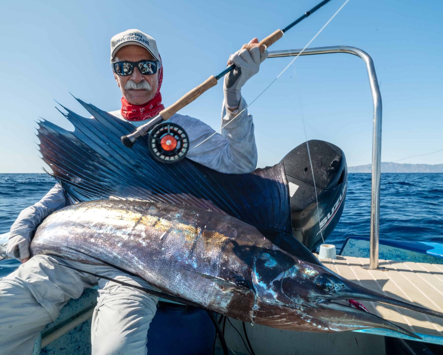 Fly fisherman holding a marlin caught in baja mexico