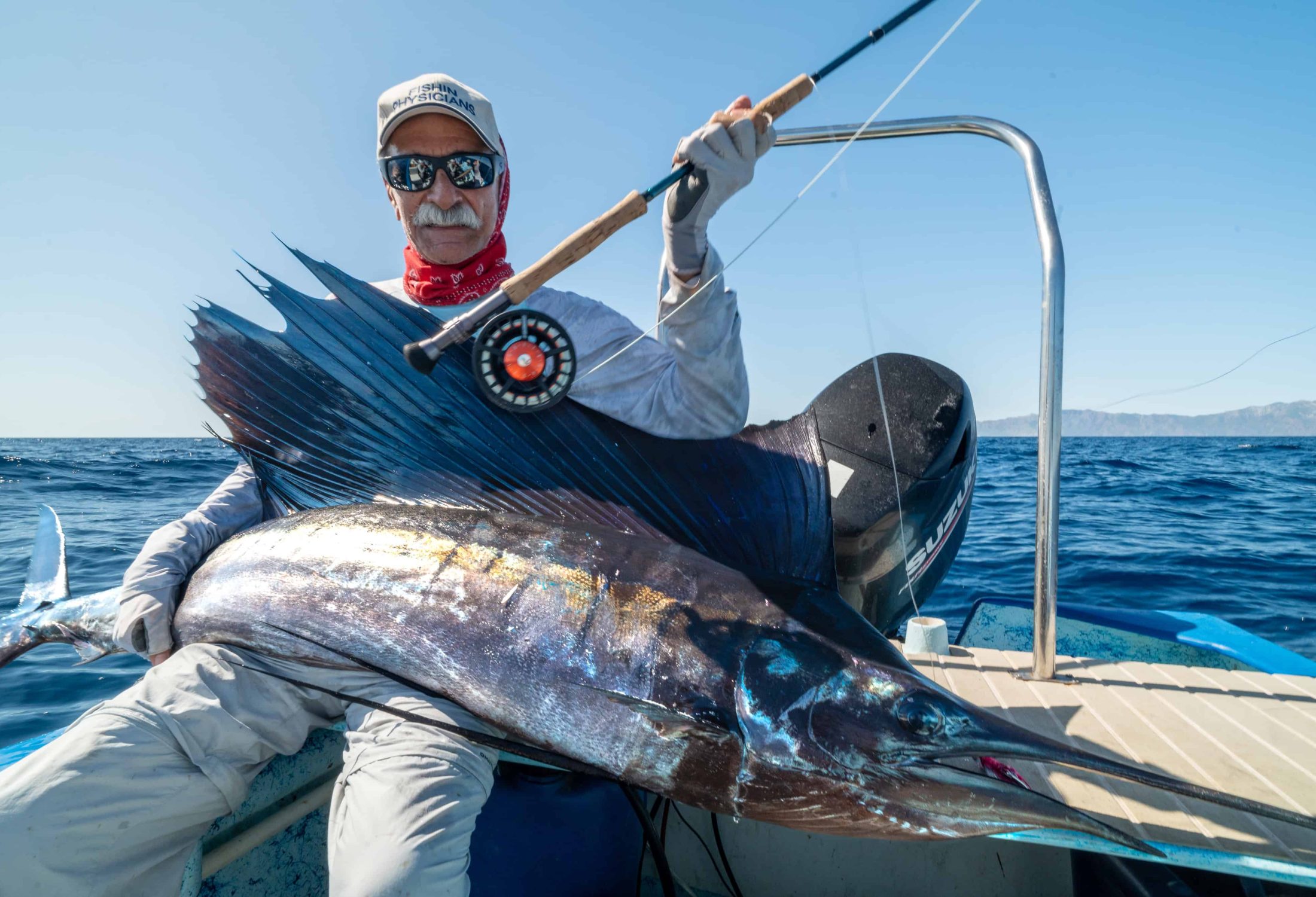 Fly fisherman holding a marlin caught in baja mexico