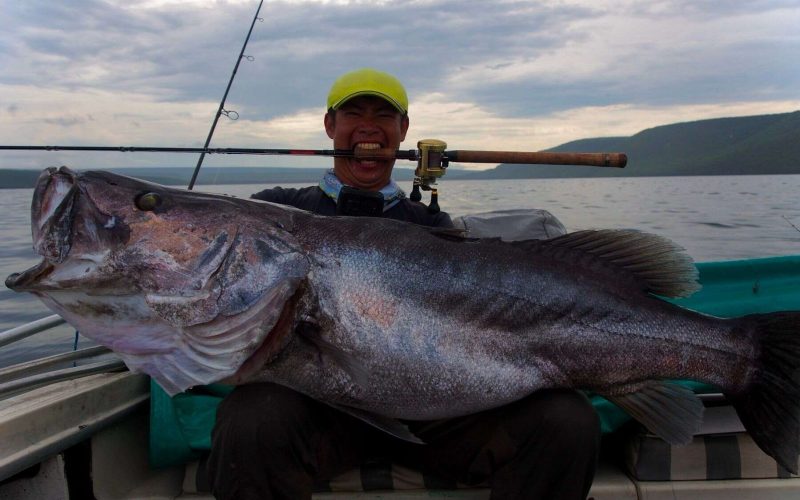 angler posing with tanganyikan perch caught in lake tanganyika