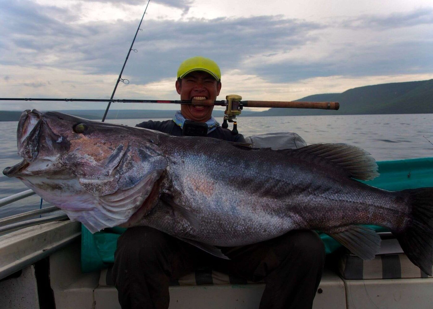 angler posing with tanganyikan perch caught in lake tanganyika