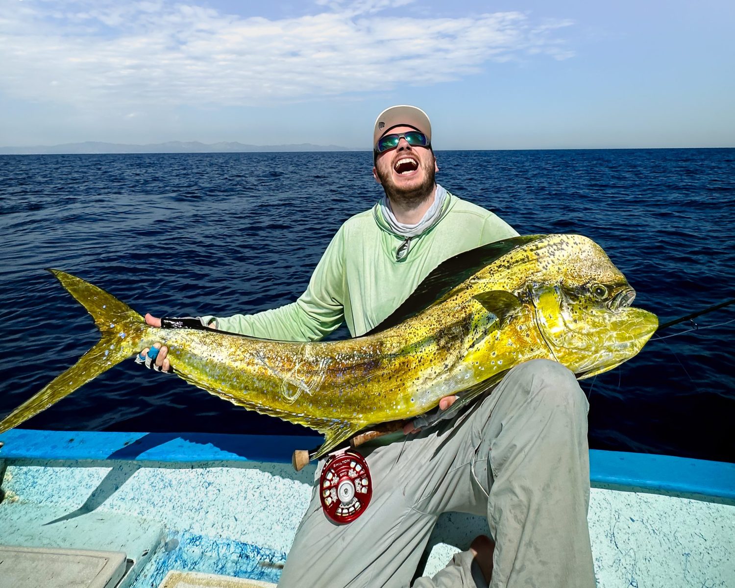 Fly fisherman holding a dorado caught in baja mexico