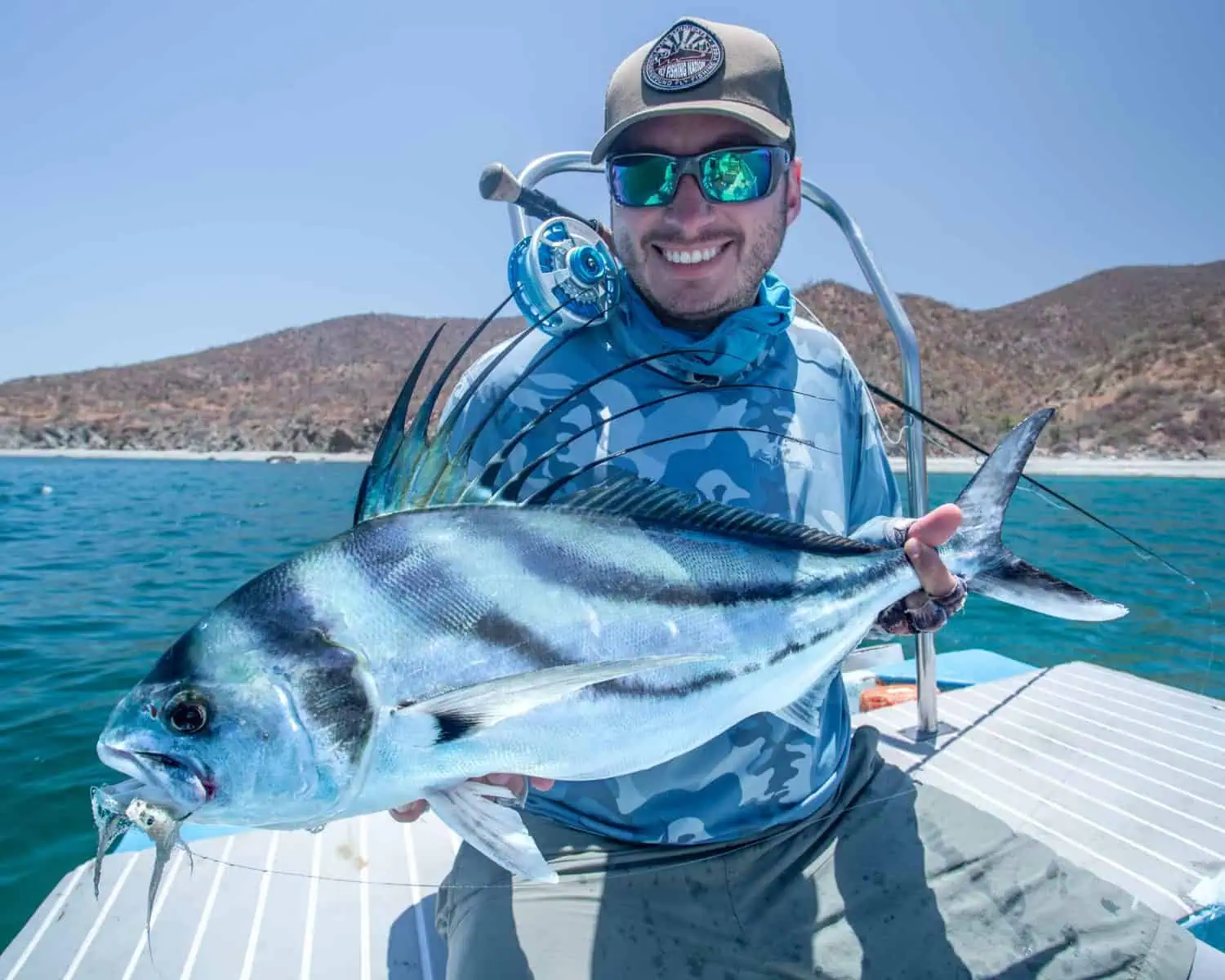 Fly fisherman holding a roosterfish caught in baja mexico
