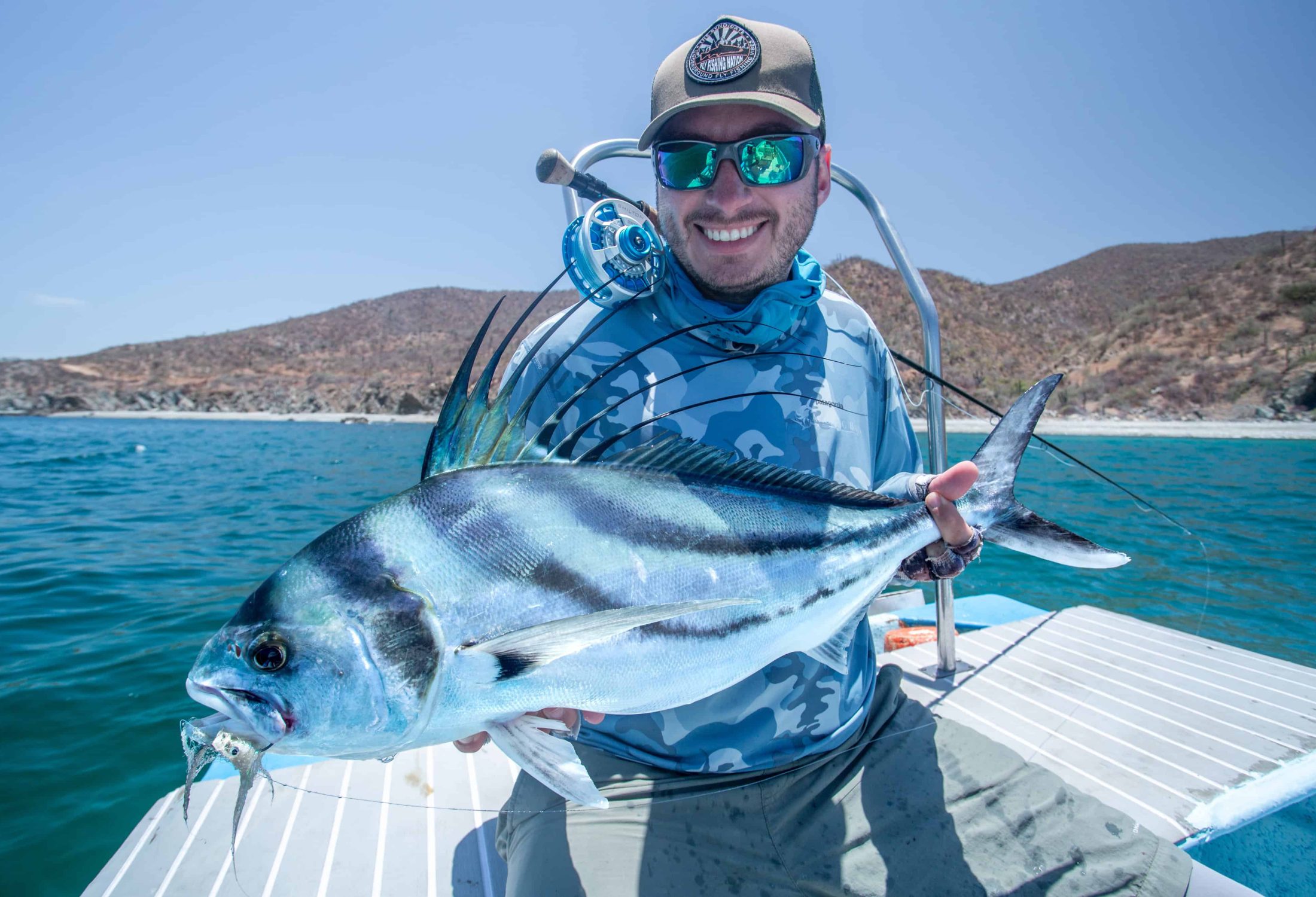 Fly fisherman holding a roosterfish caught in baja mexico
