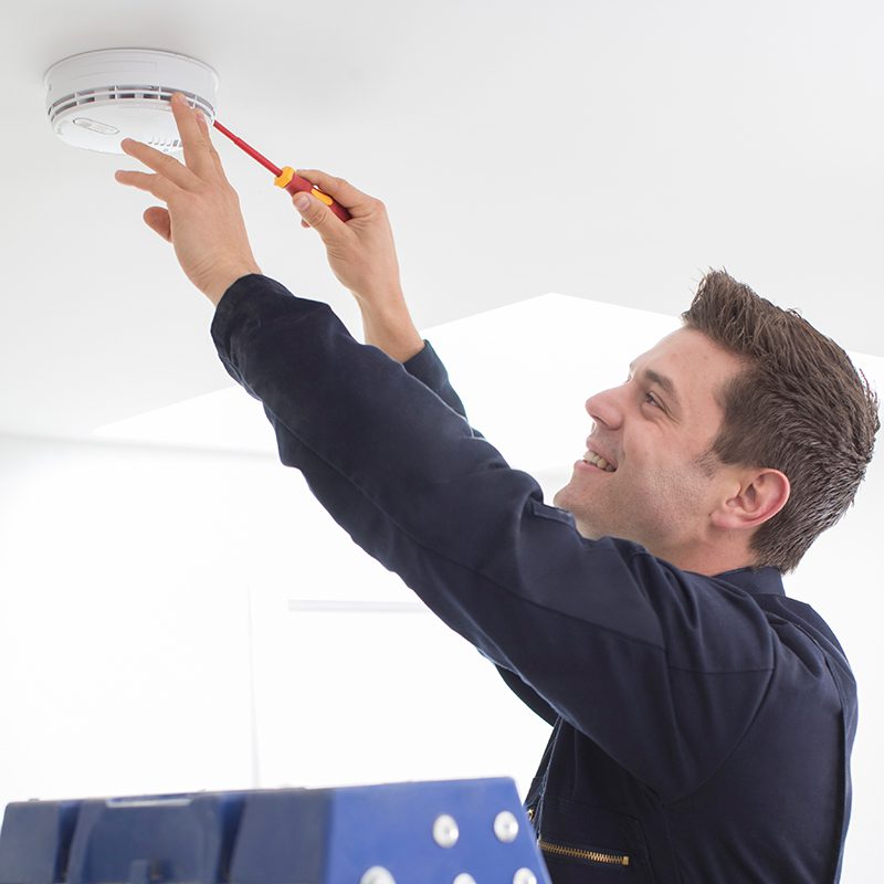 Man Installing Smoke Or Carbon Monoxide Detector