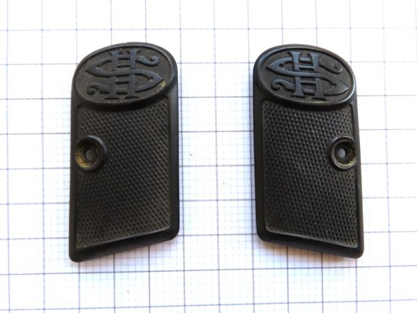 Close-up of black rubber pistol grips featuring C.A.C logo, ideal for firearm accessories.