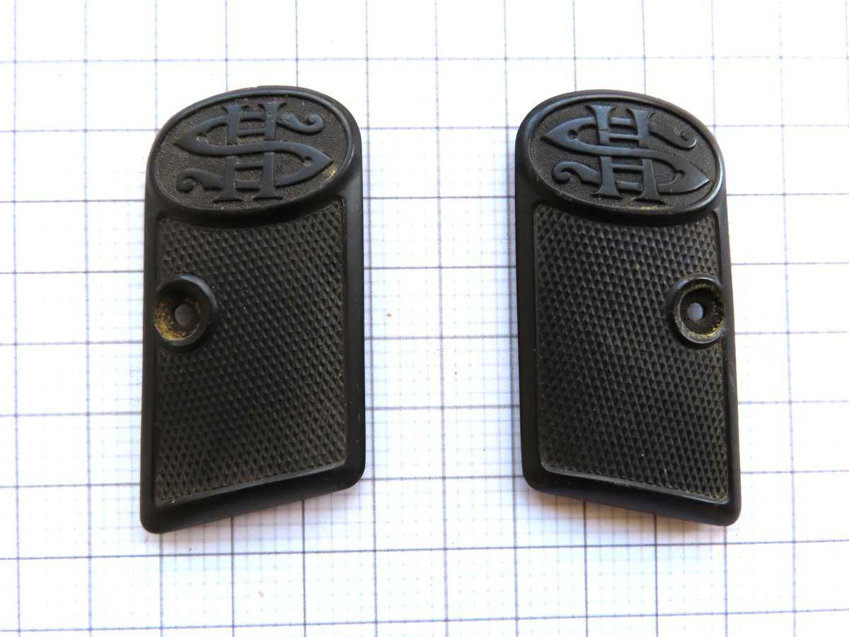 Close-up of black rubber pistol grips featuring C.A.C logo, ideal for firearm accessories.