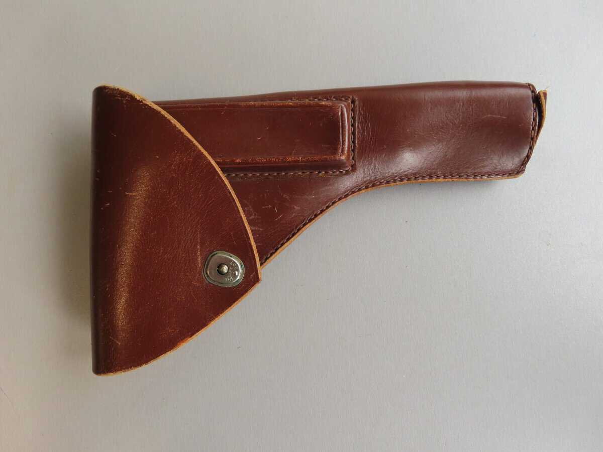 Leather gun holster with retention strap, ideal for shooting sports and hunting.