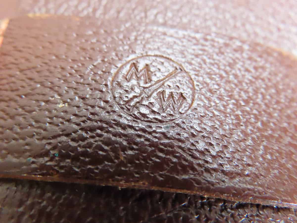 Close-up of leather embossed with Colonial Ammunition Company logo, highlighting collectible firearm accessories.