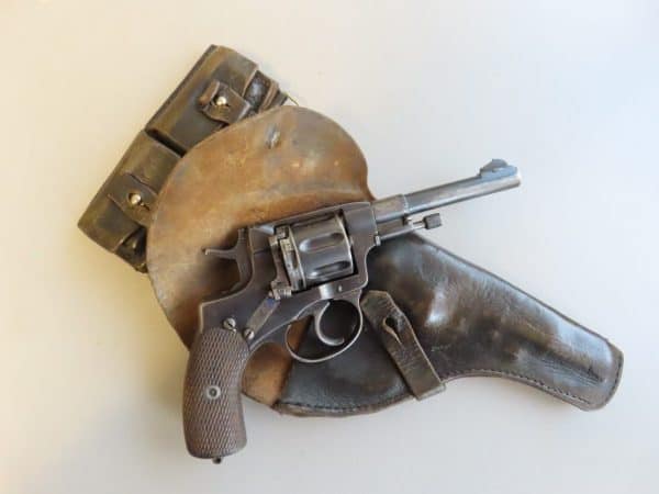 High-quality image of a vintage Colt revolver, leather holster, and ammunition belt showcasing antique firearm accessories.
