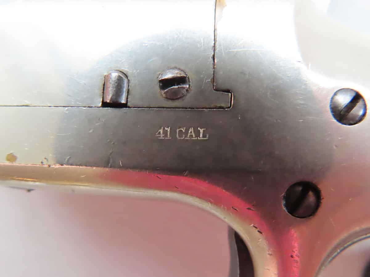 Close-up of a firearm with "44 CAL" engraving, highlighting vintage ammunition and gun collector details.