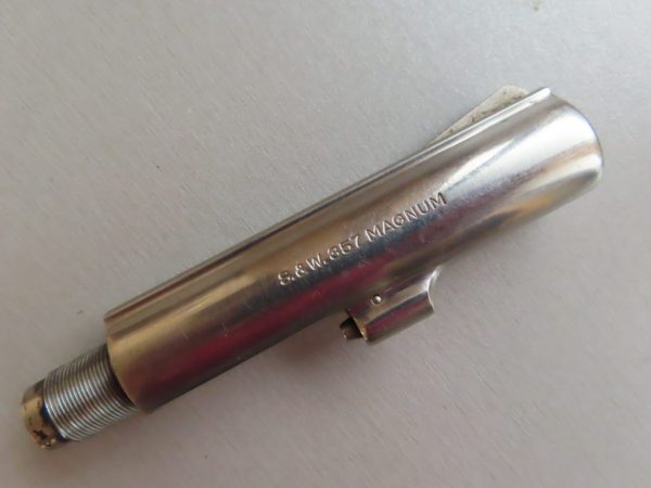 Close-up of a polished, stainless steel firearm barrel engraved with ".357 Magnum".