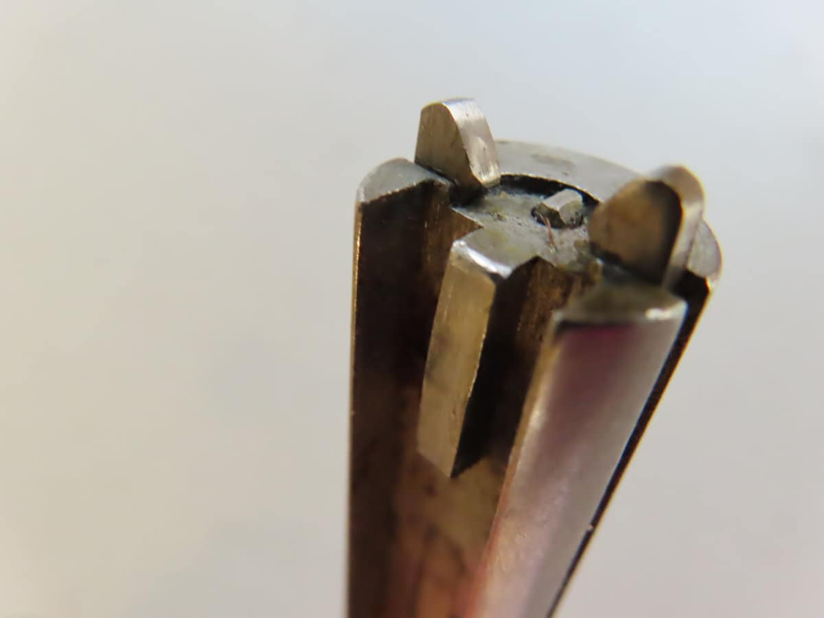 Close-up of a vintage ammunition cartridge headstamp with detailed metal markings.