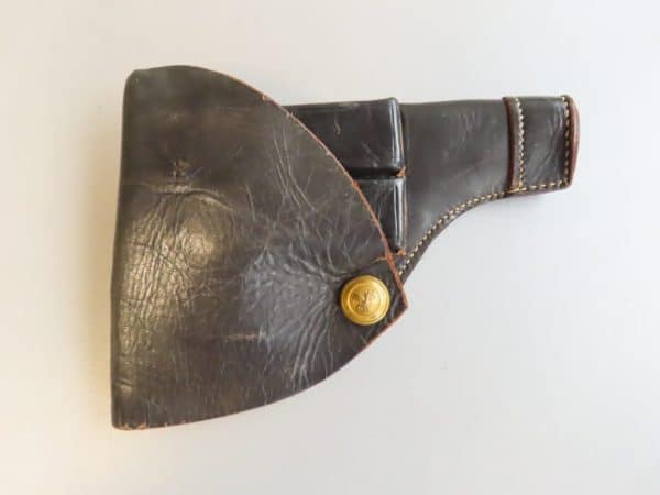 Vintage leather ammunition holster with brass button closure, used for firearm cartridges.