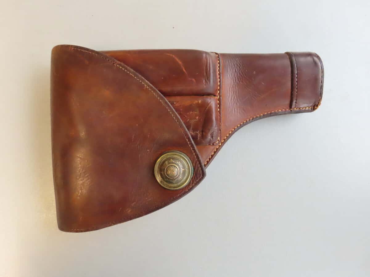 Leather gun holster with brass snap closure, ideal for firearm enthusiasts and collectors.