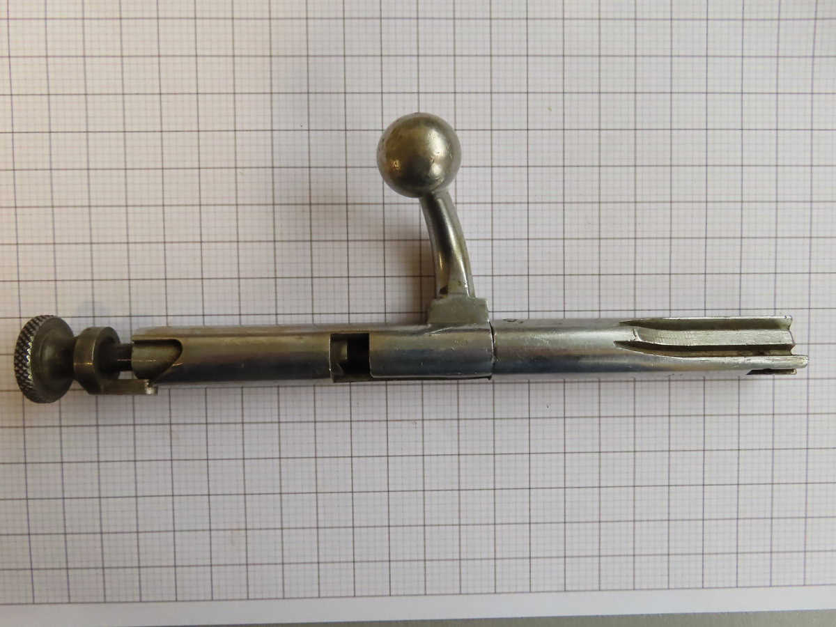 Antique metal ammunition loader used for reloading cartridges, part of historical firearms and shooting equipment.