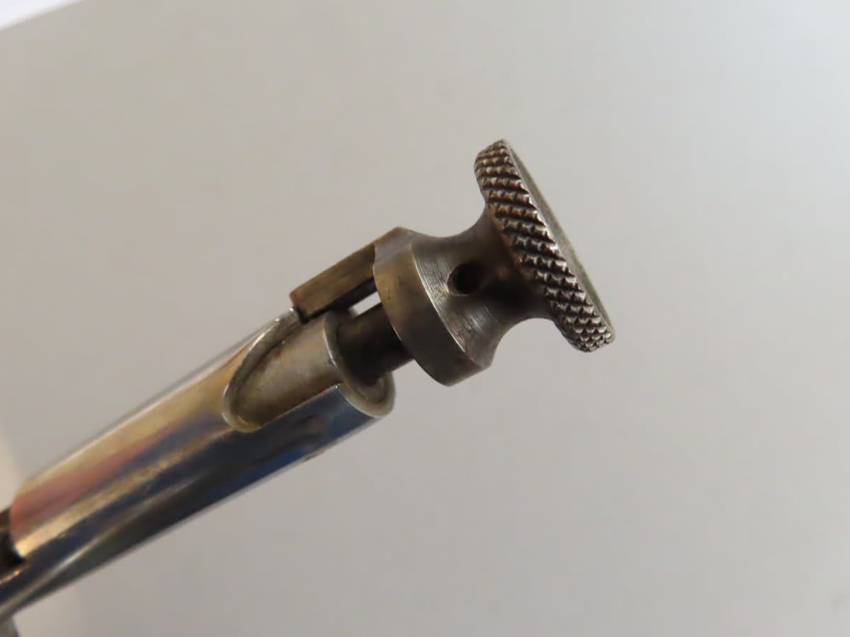Close-up of a firearm cleaning brush with textured metal bristles, designed for firearm maintenance.