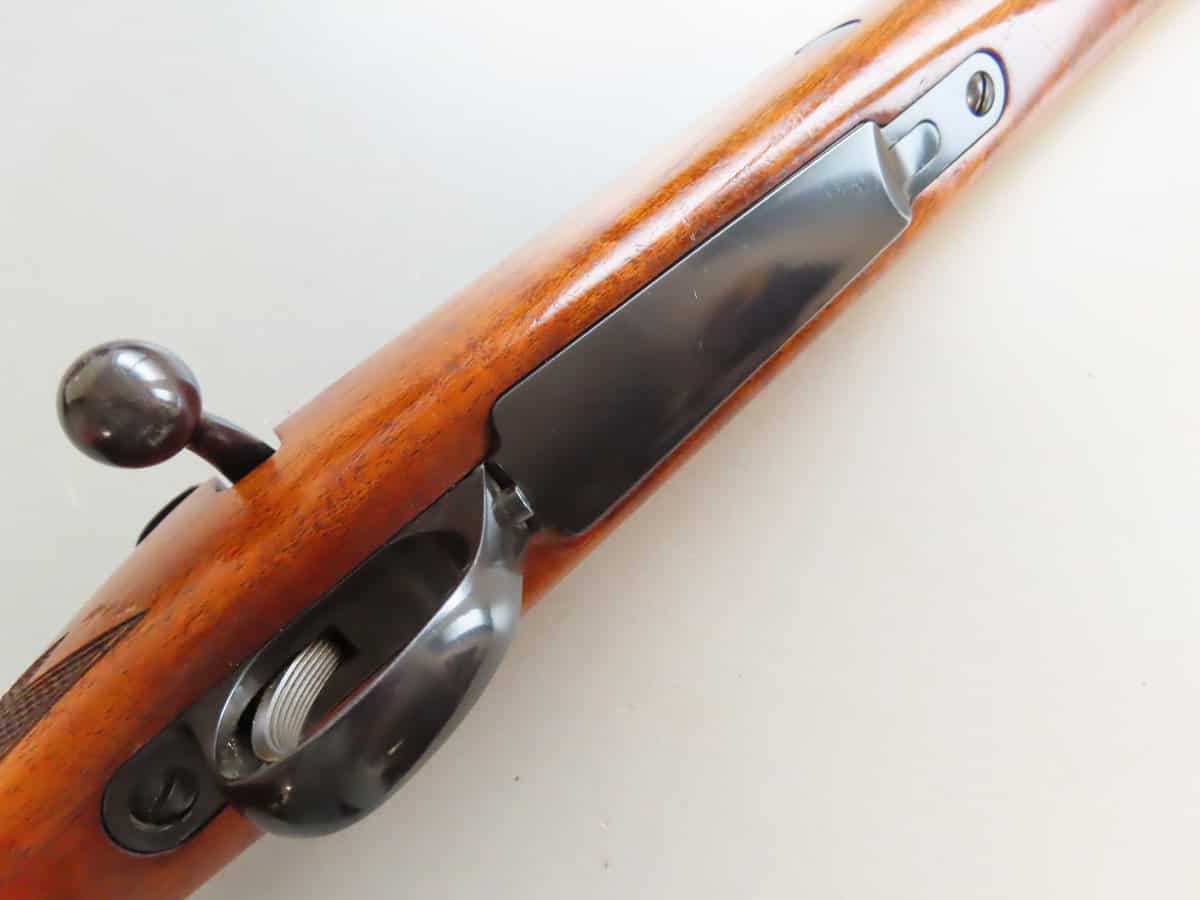 Vintage firearm with wooden stock, showcasing traditional ammunition handling and shooting.