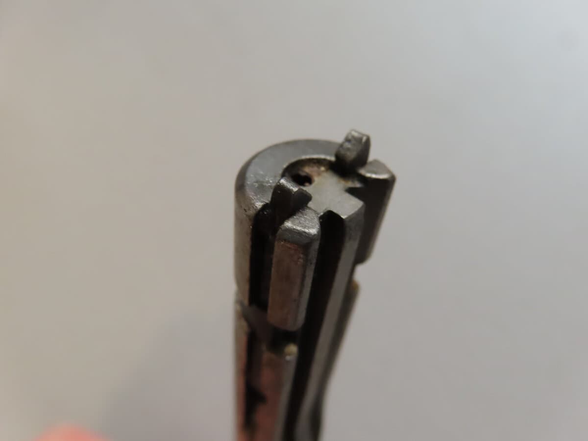 Close-up of vintage ammunition component, showcasing precise metal craftsmanship.
