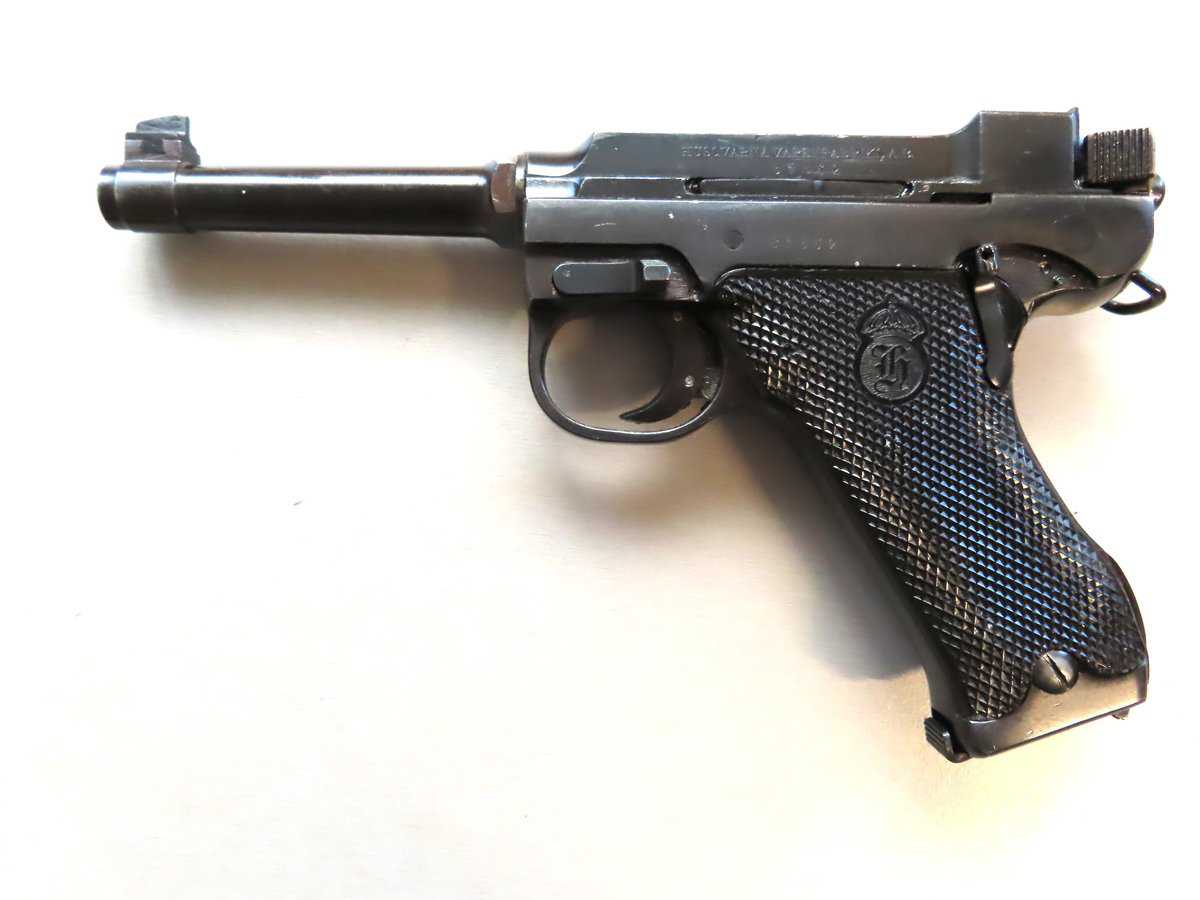 Vintage Colt 1911-style semi-automatic pistol with black grips and metal finish.