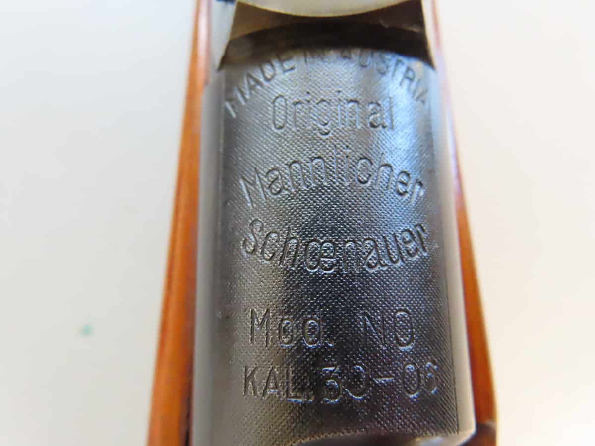 Close-up of a vintage ammunition cartridge showing embossed markings.