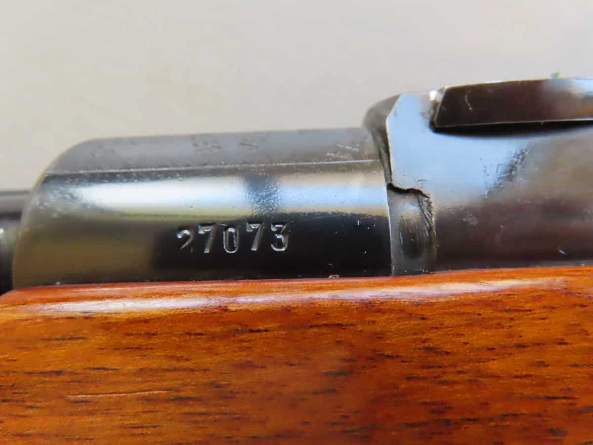 Close-up of a firearm serial number 27073 engraved on metal, highlighting historical firearm collectors and ammunition expertise.