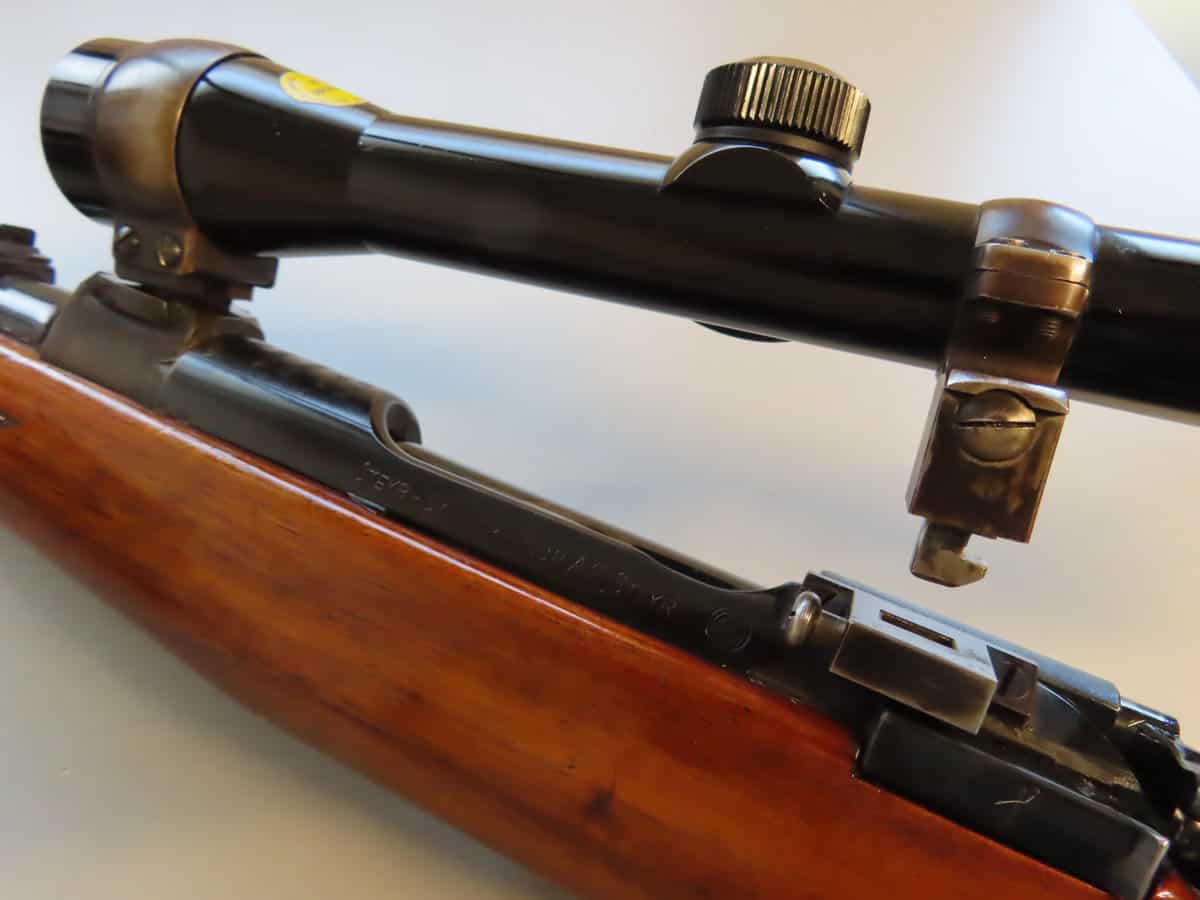 Close-up of classic bolt-action rifle with scope, showcasing firearm accessories from Colonial Ammunition Company.