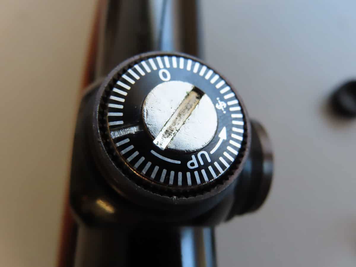 Close-up of a vintage firearm safety dial with clear markings for safe and fire positions.