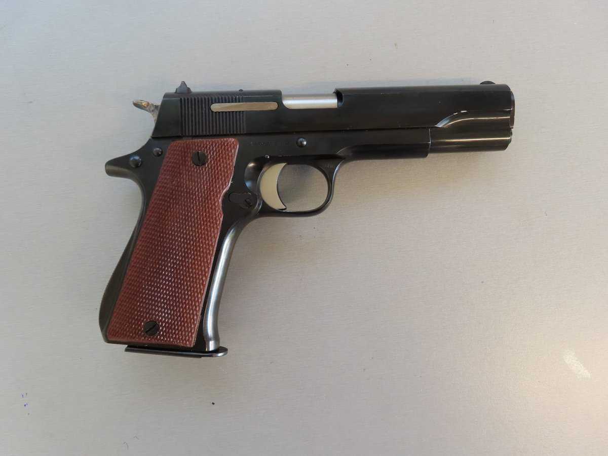 Vintage firearm with wooden grips and slide action. Perfect for collectors and shooting enthusiasts.