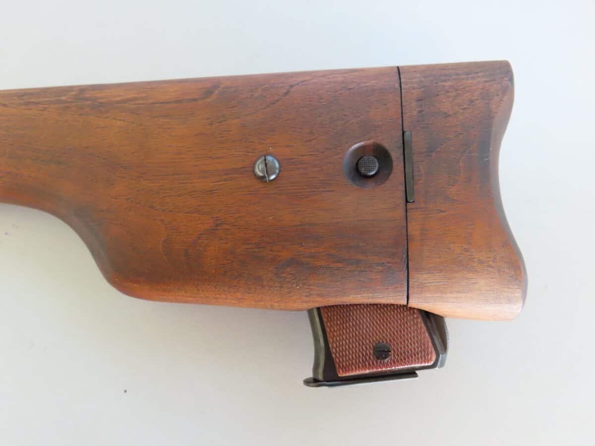 Wooden rifle stock with bolt action mechanism shown against a white background.