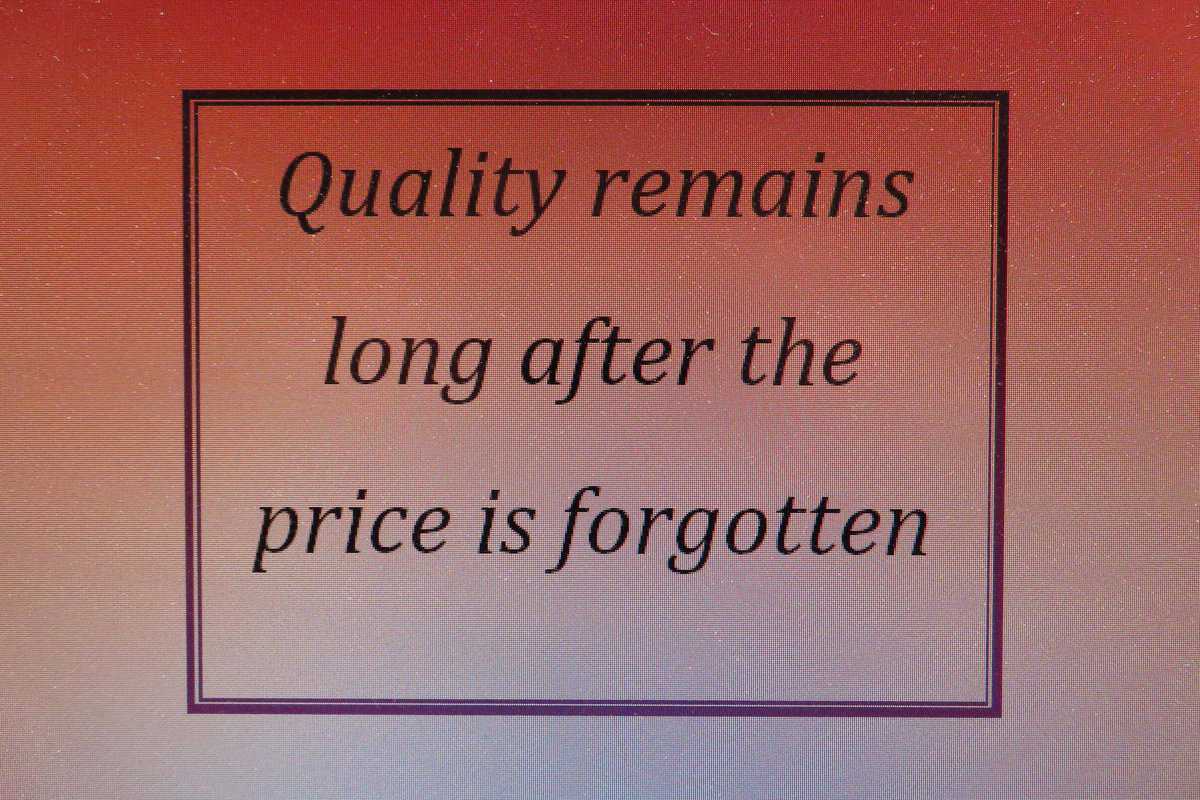 Close-up of vintage ammunition company billboard with a quote about quality and price history.