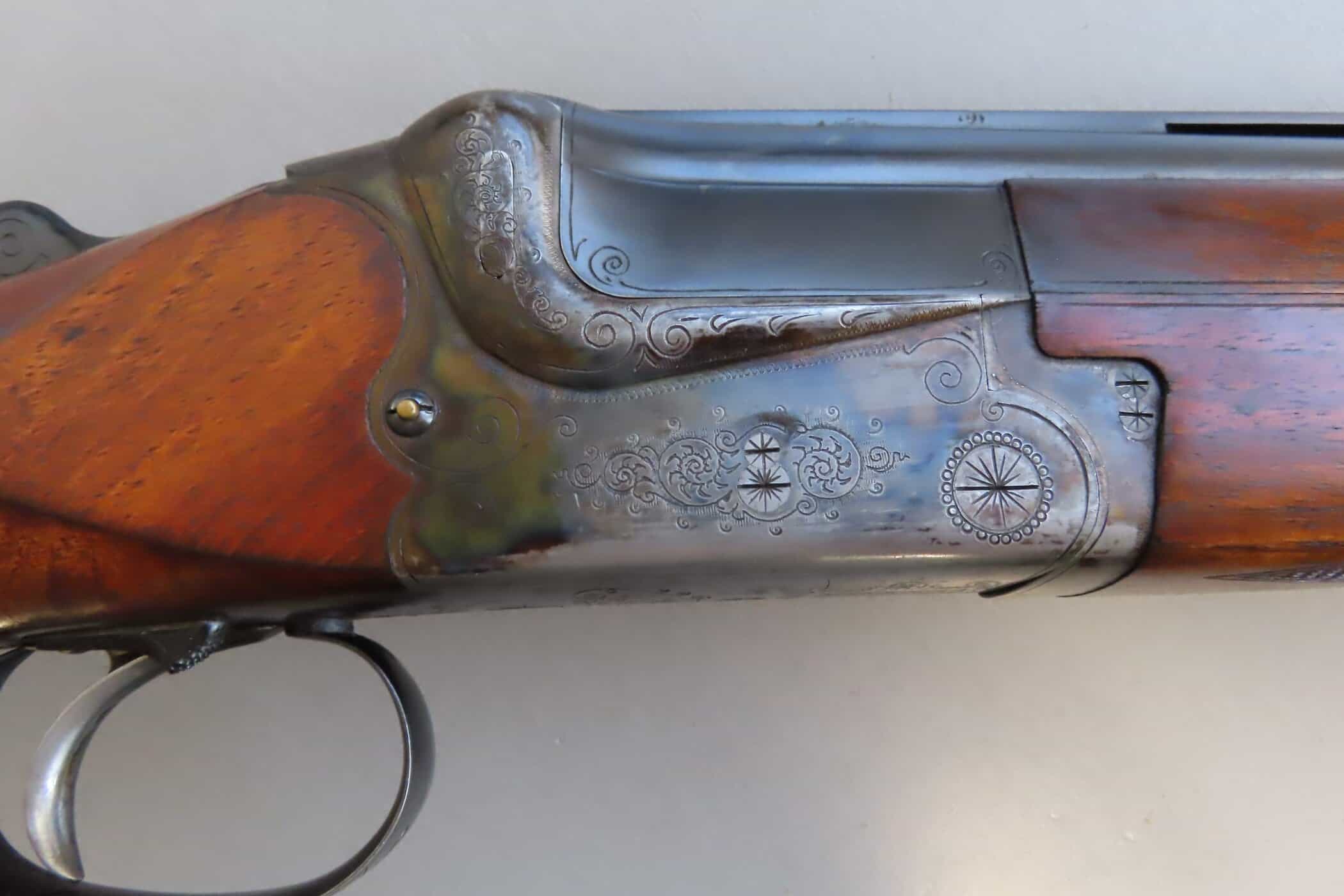 A vintage lever-action rifle showcasing detailed engravings and wooden stock, displayed by Colonial Ammunition Company New Zealand.