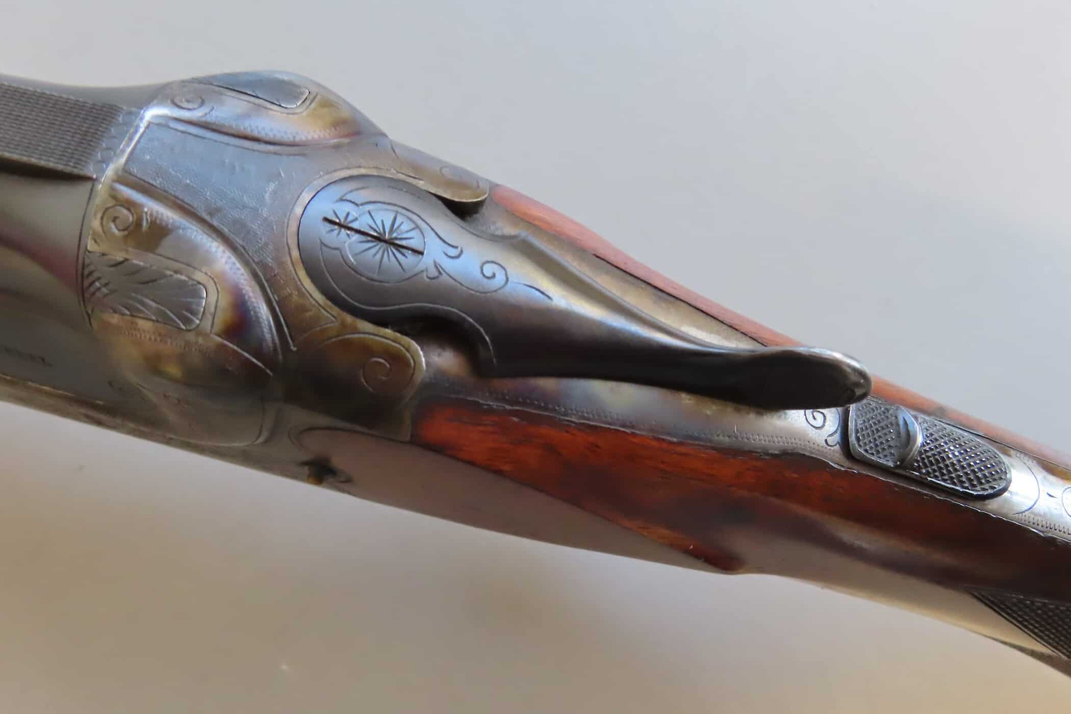 Antique firearm with detailed silver inlays and engraved patterns, highlighting historical colonial craftsmanship.