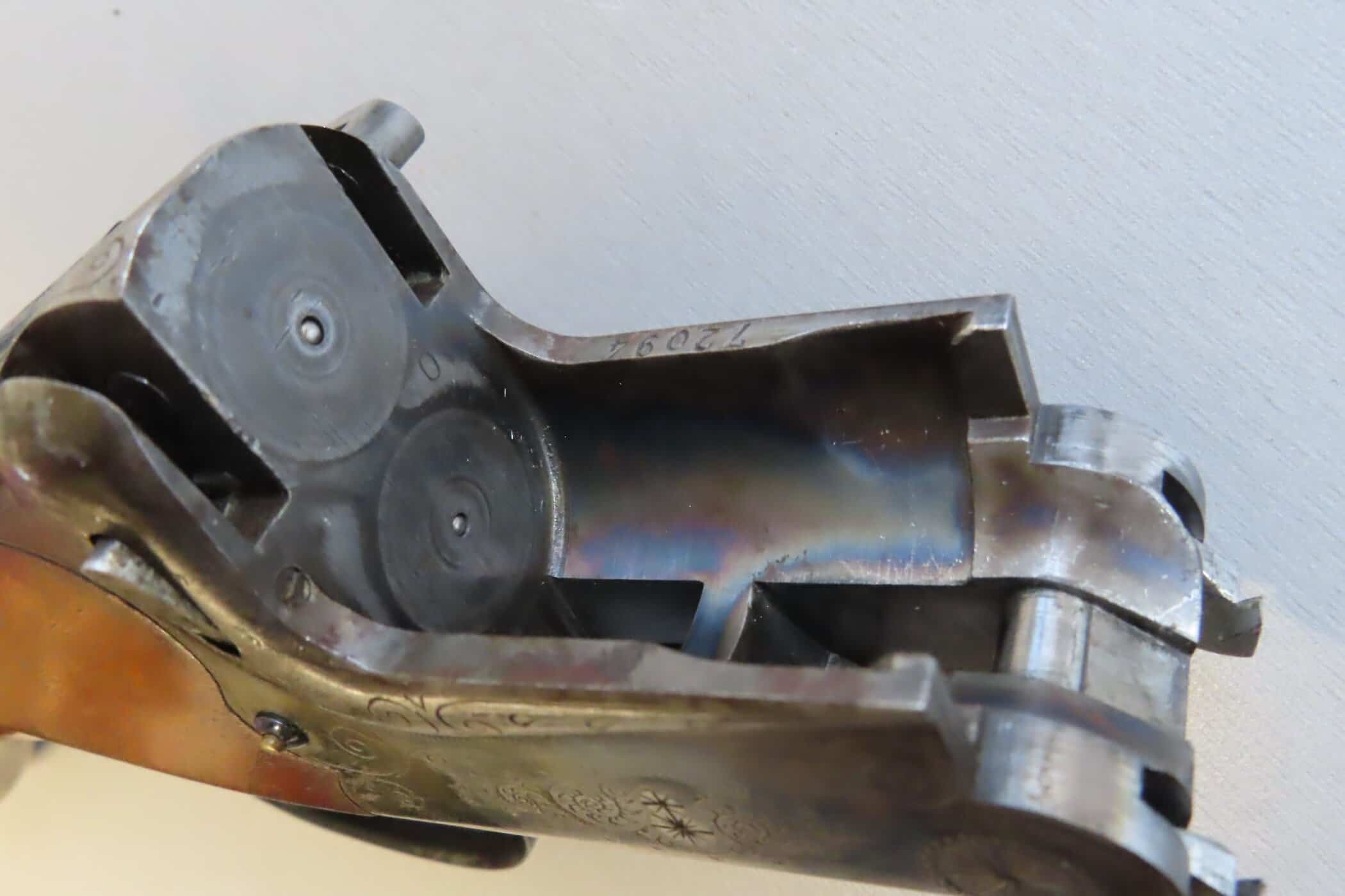 Detailed view of an antique metallic firearm part, highlighting precision engineering and historical firearm design.