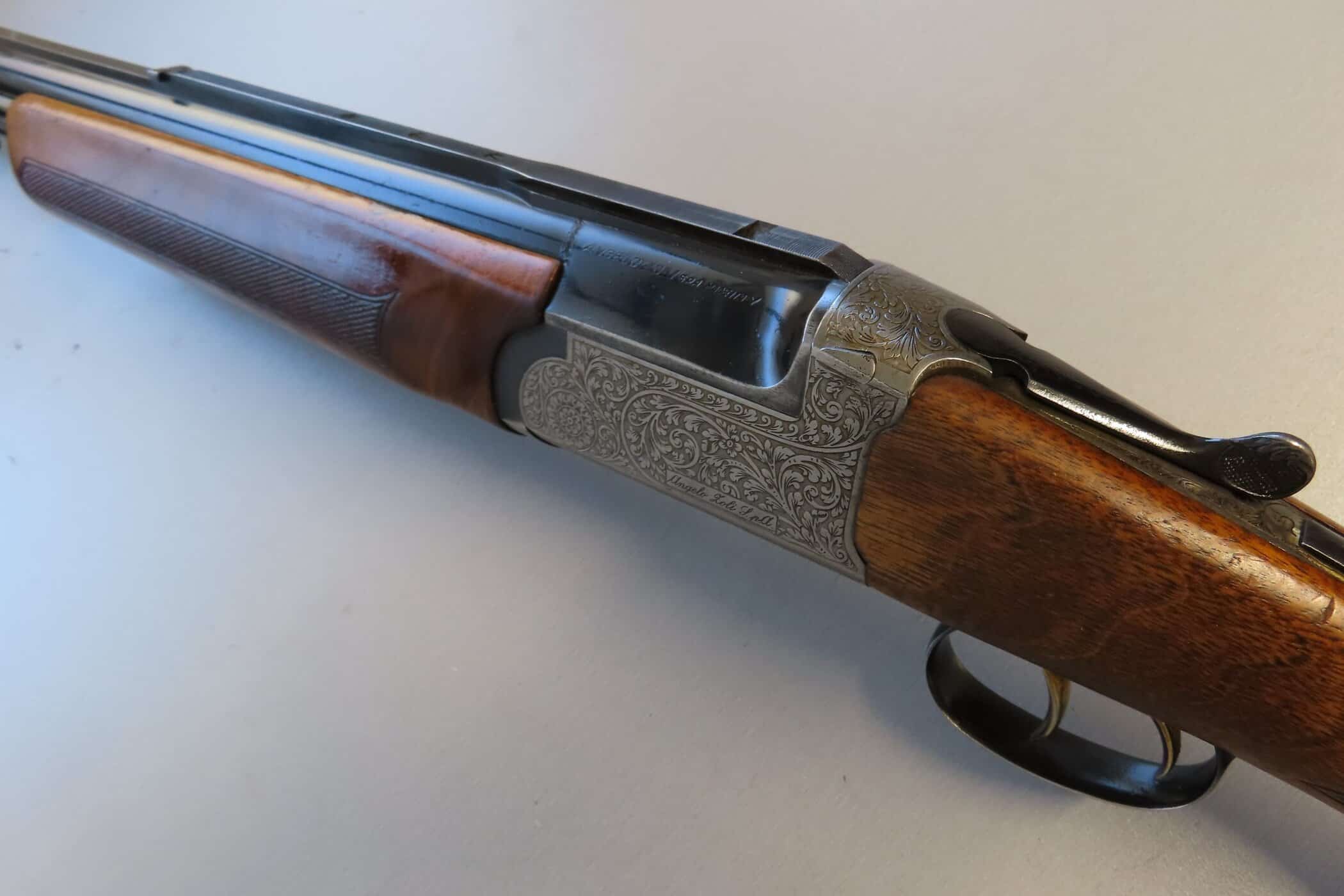 Detailed engraved metalwork on classic rifle with wooden stock, collectible ammunition firearm NZ.