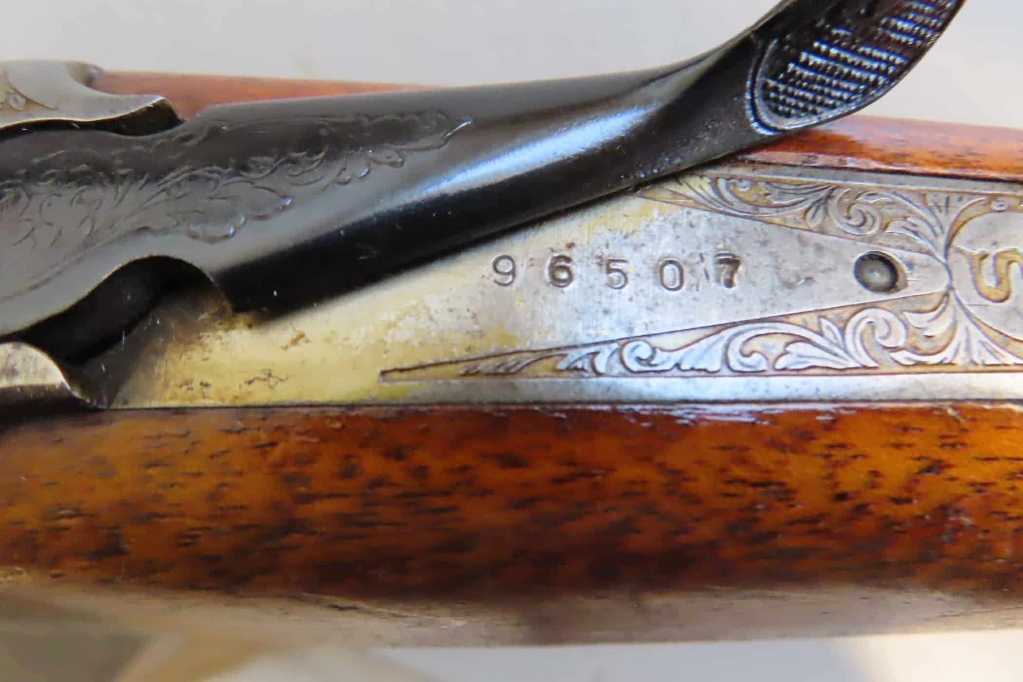 Close-up of engraved serial number on vintage firearm by Colonial Ammunition Company.
