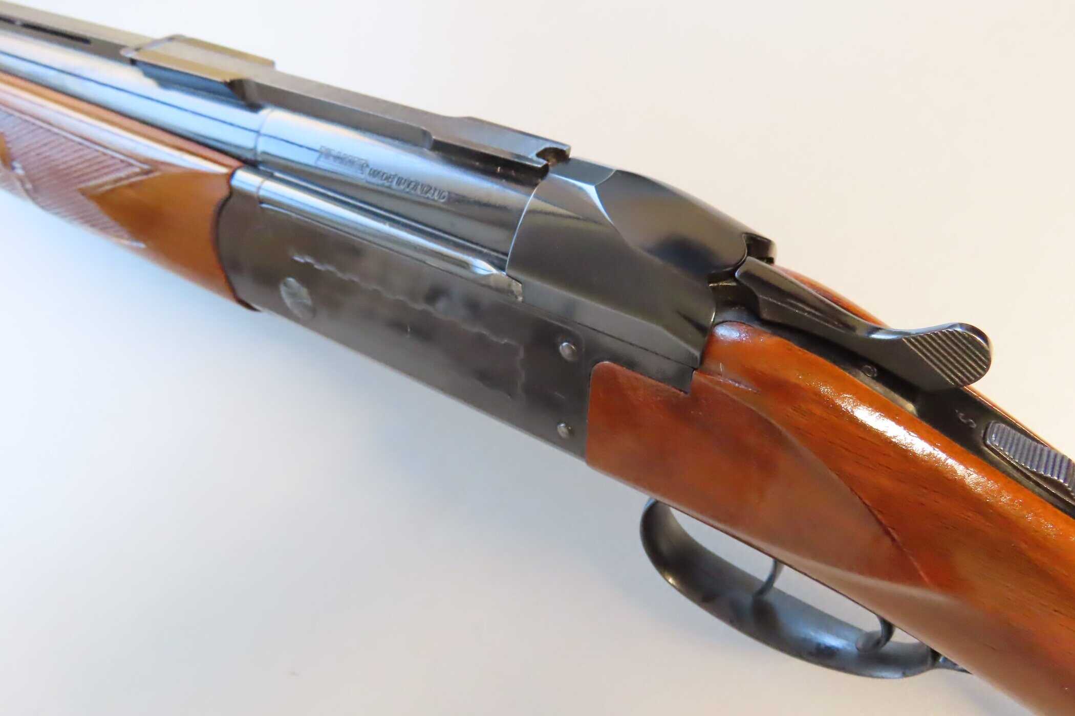 Detailed close-up of a classic rifle highlighting its wood finish and metallic components for collectors.